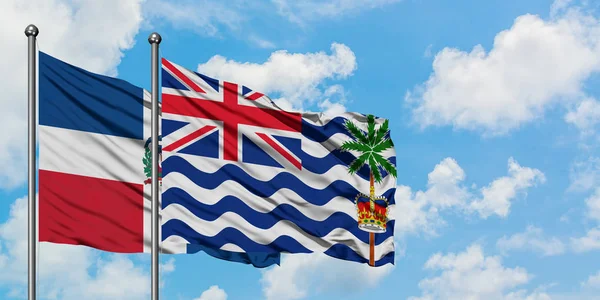 Bandera de la República Dominicana y del Territorio Británico del Océano Índico ondeando en el viento contra el cielo azul nublado blanco juntos. Concepto diplomático, relaciones internacionales . — Foto de Stock