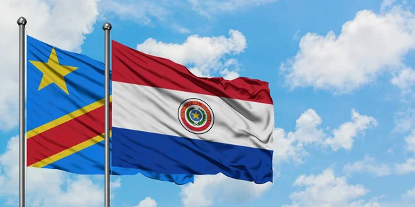 Bandera del Congo y Paraguay ondeando en el viento contra el cielo azul nublado blanco juntos. Concepto diplomático, relaciones internacionales . — Foto de Stock