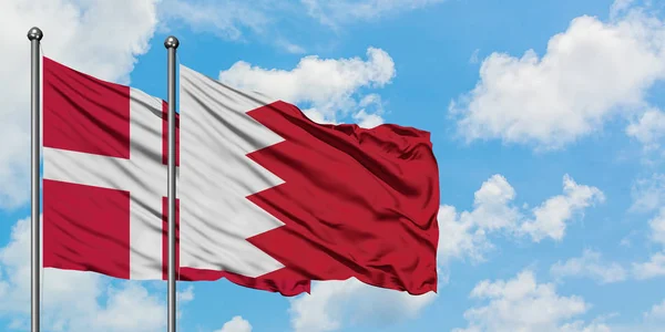 Данія і Бахрейн прапор розмахуючи в вітру проти білого хмарного синього неба разом. Концепція дипломатії, міжнародні відносини. — стокове фото