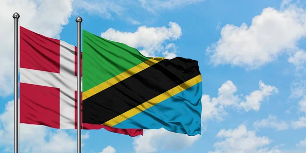 Dania i Tanzania Flaga Macha w wiatr przed białym zachmurzone błękitne niebo razem. Koncepcja dyplomacji, stosunki międzynarodowe. — Zdjęcie stockowe