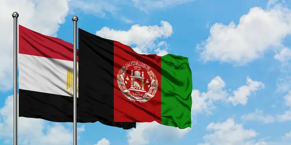 Bandera de Egipto y Afganistán ondeando en el viento contra el cielo azul nublado blanco juntos. Concepto diplomático, relaciones internacionales . — Foto de Stock