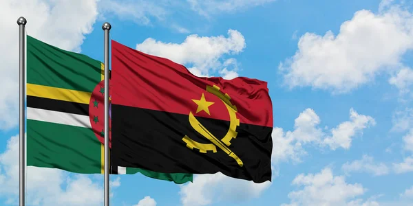 Drapeau de la Dominique et de l'Angola agitant dans le vent contre ciel bleu nuageux blanc ensemble. Concept de diplomatie, relations internationales . — Photo