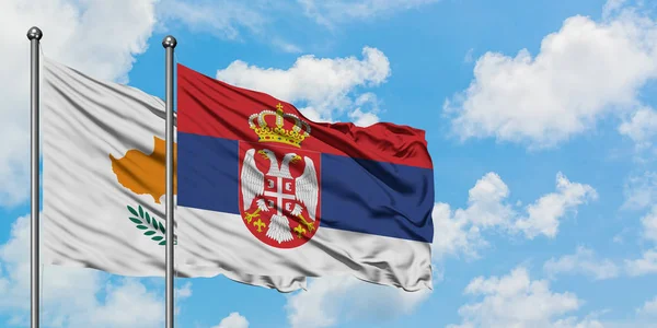 Bandera de Chipre y Serbia ondeando en el viento contra el cielo azul nublado blanco juntos. Concepto diplomático, relaciones internacionales . — Foto de Stock