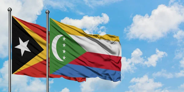 East Timor and Comoros flag waving in the wind against white cloudy blue sky together. Diplomacy concept, international relations. — Stock Photo, Image