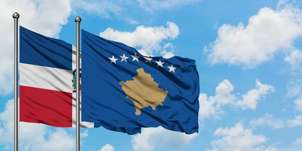 Bandera de República Dominicana y Kosovo ondeando en el viento contra el cielo azul nublado blanco juntos. Concepto diplomático, relaciones internacionales . — Foto de Stock