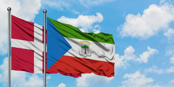 Bandera de Dinamarca y Guinea Ecuatorial ondeando en el viento contra el cielo azul nublado blanco juntos. Concepto diplomático, relaciones internacionales . — Foto de Stock