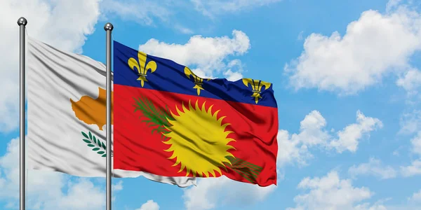 Bandera de Chipre y Guadalupe ondeando en el viento contra el cielo azul nublado blanco juntos. Concepto diplomático, relaciones internacionales . — Foto de Stock