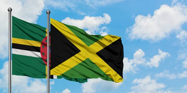 Dominica and Jamaica flag waving in the wind against white cloudy blue sky together. Diplomacy concept, international relations. — Stock Photo, Image