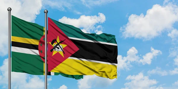Dominica and Mozambique flag waving in the wind against white cloudy blue sky together. Diplomacy concept, international relations. — Stock Photo, Image