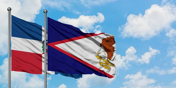 República Dominicana e bandeira Samoa Americana acenando no vento contra o céu azul nublado branco juntos. Conceito de diplomacia, relações internacionais . — Fotografia de Stock