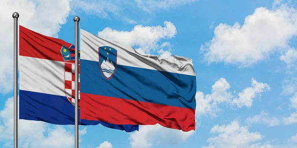 Bandera de Croacia y Eslovenia ondeando en el viento contra el cielo azul nublado blanco juntos. Concepto diplomático, relaciones internacionales . — Foto de Stock