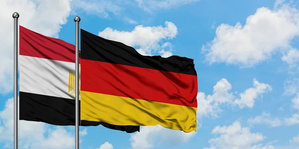 Egypten och Tyskland flagga viftande i vinden mot vit grumlig blå himmel tillsammans. Begreppet diplomati, internationella förbindelser. — Stockfoto