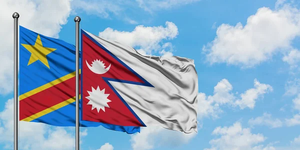 Bandera del Congo y Nepal ondeando en el viento contra el cielo azul nublado blanco juntos. Concepto diplomático, relaciones internacionales . — Foto de Stock