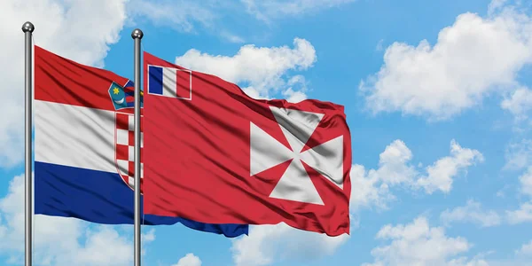 Croacia y Wallis Y la bandera de Futuna ondeando en el viento contra el cielo azul nublado blanco juntos. Concepto diplomático, relaciones internacionales . — Foto de Stock