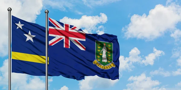 Curacao og British Virgin Islands flag vinker i vinden mod hvid overskyet blå himmel sammen. Diplomati koncept, internationale relationer . - Stock-foto