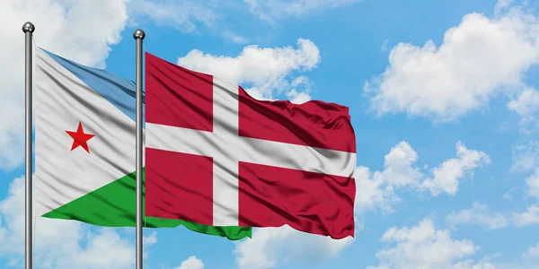 Bandera de Djibouti y Dinamarca ondeando en el viento contra el cielo azul nublado blanco juntos. Concepto diplomático, relaciones internacionales . — Foto de Stock