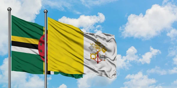 Dominica y la bandera de la Ciudad del Vaticano ondeando en el viento contra el blanco cielo azul nublado juntos. Concepto diplomático, relaciones internacionales . — Foto de Stock