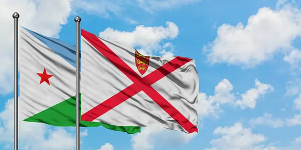 Djibouti och Jersey flagga viftande i vinden mot vit grumlig blå himmel tillsammans. Diplomatisk koncept, internationella relationer. — Stockfoto