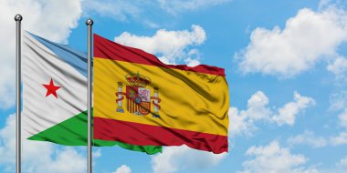 Cibuti ve İspanya bayrağı birlikte beyaz bulutlu mavi gökyüzüne karşı rüzgarda sallayarak. Diplomasi kavramı, uluslararası ilişkiler.