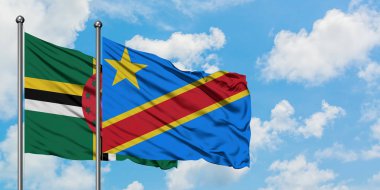 Dominika ve Kongo bayrağı birlikte beyaz bulutlu mavi gökyüzüne karşı rüzgarda sallayarak. Diplomasi kavramı, uluslararası ilişkiler.