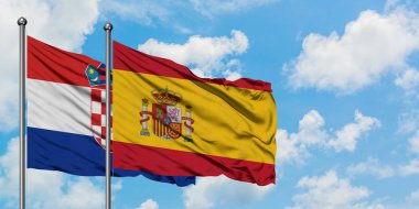 Hırvatistan ve İspanya bayrağı birlikte beyaz bulutlu mavi gökyüzüne karşı rüzgarda sallayarak. Diplomasi kavramı, uluslararası ilişkiler.