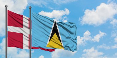 Danimarka ve Saint Lucia bayrağı birlikte beyaz bulutlu mavi gökyüzüne karşı rüzgarda sallayarak. Diplomasi kavramı, uluslararası ilişkiler.