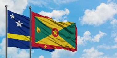 Curacao ve Grenada bayrağı birlikte beyaz bulutlu mavi gökyüzüne karşı rüzgarda sallayarak. Diplomasi kavramı, uluslararası ilişkiler.