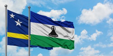 Curacao ve Lesotho bayrak birlikte beyaz bulutlu mavi gökyüzüne karşı rüzgarda sallayarak. Diplomasi kavramı, uluslararası ilişkiler.