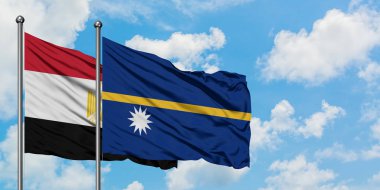 Mısır ve Nauru bayrağı birlikte beyaz bulutlu mavi gökyüzüne karşı rüzgarda sallayarak. Diplomasi kavramı, uluslararası ilişkiler.