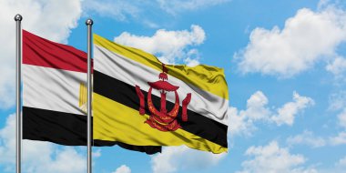 Mısır ve Brunei bayrağı birlikte beyaz bulutlu mavi gökyüzüne karşı rüzgarda sallayarak. Diplomasi kavramı, uluslararası ilişkiler.