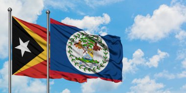 Doğu Timor ve Belize bayrağı birlikte beyaz bulutlu mavi gökyüzüne karşı rüzgarda sallayarak. Diplomasi kavramı, uluslararası ilişkiler.