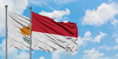 Kıbrıs ve Monako bayrağı birlikte beyaz bulutlu mavi gökyüzüne karşı rüzgarsal sallayarak. Diplomasi kavramı, uluslararası ilişkiler.