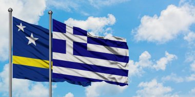 Curacao ve Yunanistan bayrağı birlikte beyaz bulutlu mavi gökyüzüne karşı rüzgarda sallayarak. Diplomasi kavramı, uluslararası ilişkiler.