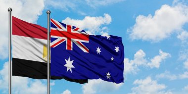 Mısır ve Avustralya bayrağı birlikte beyaz bulutlu mavi gökyüzüne karşı rüzgarda sallayarak. Diplomasi kavramı, uluslararası ilişkiler.