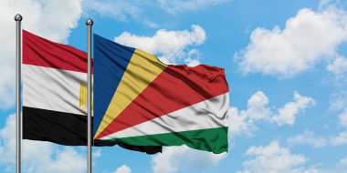 Mısır ve Seyşeller bayrağı birlikte beyaz bulutlu mavi gökyüzüne karşı rüzgarda sallayarak. Diplomasi kavramı, uluslararası ilişkiler.