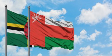 Dominika ve Umman bayrağı birlikte beyaz bulutlu mavi gökyüzüne karşı rüzgarda sallayarak. Diplomasi kavramı, uluslararası ilişkiler.