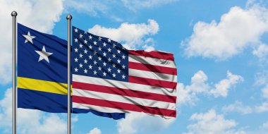 Curacao ve Amerika Birleşik Devletleri bayrağı birlikte beyaz bulutlu mavi gökyüzüne karşı rüzgarda sallayarak. Diplomasi kavramı, uluslararası ilişkiler.