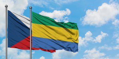 Çek Cumhuriyeti ve Gabon bayrağı birlikte beyaz bulutlu mavi gökyüzüne karşı rüzgarda sallayarak. Diplomasi kavramı, uluslararası ilişkiler.