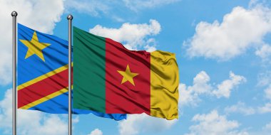 Kongo ve Kamerun bayrağı birlikte beyaz bulutlu mavi gökyüzüne karşı rüzgarsal sallayarak. Diplomasi kavramı, uluslararası ilişkiler.