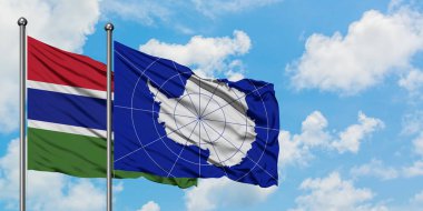 Gambiya ve Antarktika bayrağı birlikte beyaz bulutlu mavi gökyüzüne karşı rüzgarda sallayarak. Diplomasi kavramı, uluslararası ilişkiler.