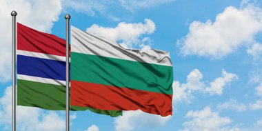 Gambiya ve Bulgaristan bayrağı birlikte beyaz bulutlu mavi gökyüzüne karşı rüzgarda sallayarak. Diplomasi kavramı, uluslararası ilişkiler.