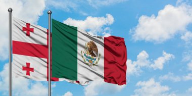 Gürcistan ve Meksika bayrağı birlikte beyaz bulutlu mavi gökyüzüne karşı rüzgarda sallayarak. Diplomasi kavramı, uluslararası ilişkiler.