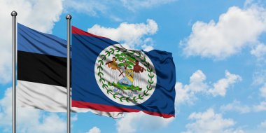 Estonya ve Belize bayrağı birlikte beyaz bulutlu mavi gökyüzüne karşı rüzgarda sallayarak. Diplomasi kavramı, uluslararası ilişkiler.