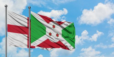 İngiltere ve Burundi bayrağı birlikte beyaz bulutlu mavi gökyüzüne karşı rüzgarda sallayarak. Diplomasi kavramı, uluslararası ilişkiler.