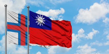 Faroe Adaları ve Tayvan bayrağı birlikte beyaz bulutlu mavi gökyüzüne karşı rüzgarda sallayarak. Diplomasi kavramı, uluslararası ilişkiler.