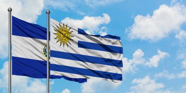 El Salvador ve Uruguay bayrağı birlikte beyaz bulutlu mavi gökyüzüne karşı rüzgarda sallayarak. Diplomasi kavramı, uluslararası ilişkiler.