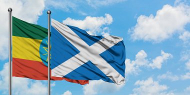 Etiyopya ve İskoçya bayrağı birlikte beyaz bulutlu mavi gökyüzüne karşı rüzgarda sallayarak. Diplomasi kavramı, uluslararası ilişkiler.