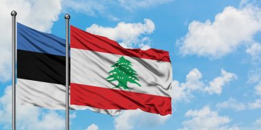 Estonya ve Lübnan bayrağı birlikte beyaz bulutlu mavi gökyüzüne karşı rüzgarda sallayarak. Diplomasi kavramı, uluslararası ilişkiler.