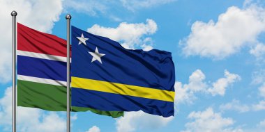 Gambiya ve Curacao bayrağı birlikte beyaz bulutlu mavi gökyüzüne karşı rüzgarda sallayarak. Diplomasi kavramı, uluslararası ilişkiler.