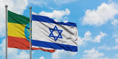 Etiyopya ve İsrail bayrağı birlikte beyaz bulutlu mavi gökyüzüne karşı rüzgarda sallayarak. Diplomasi kavramı, uluslararası ilişkiler.